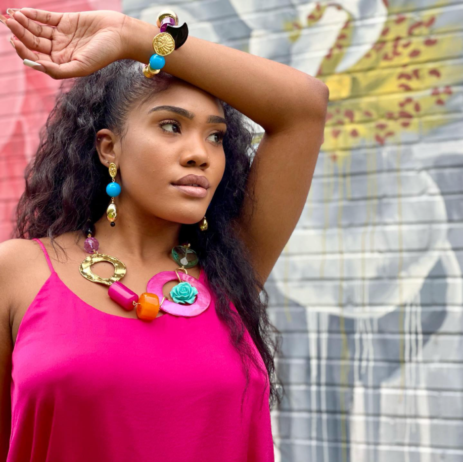 woman in hot pink tank top with big bold jewelry in multiple bright colors