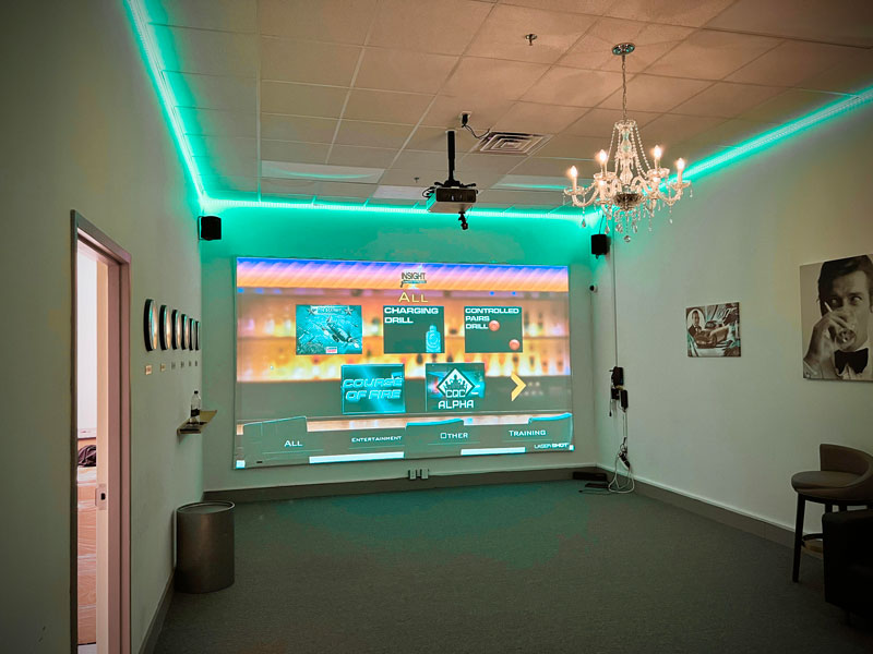 Inside Insight, a Virtual Experience room with a chandelier and a large video screen on one wall showing options of play