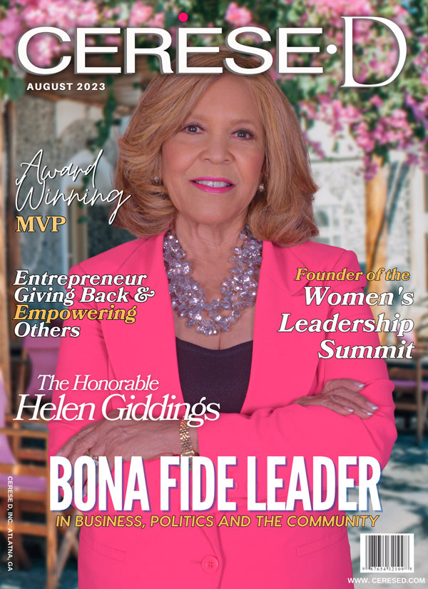 Image of a smiling woman wearing a bright pink blazer with a dark purple top underneath and a large purple beaded necklace on a Cerese D magazine cover standing in front of a floral background