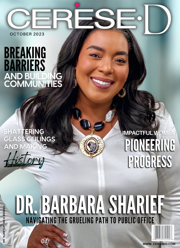 Smiling black woman wearing a white button up shirt with a large black and white beaded necklace with a large gold pendant on a Cerese D Magazine Cover